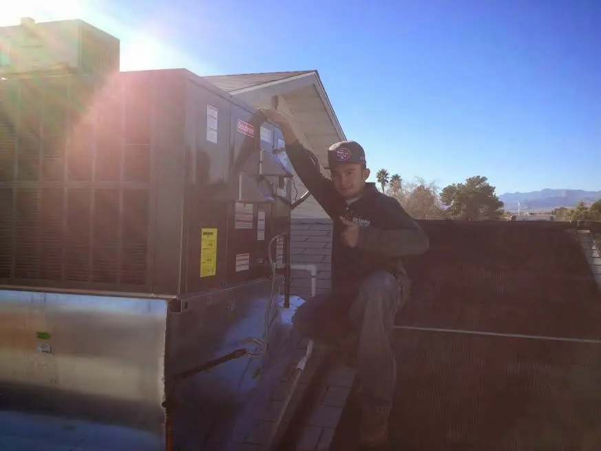 HVAC technician performing Boiler Repair on a rooftop unit in Concord